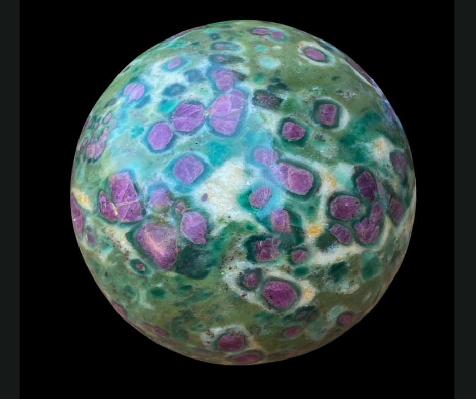Large Ruby Fuchsite Sphere on black background. Vivid red and green colors.