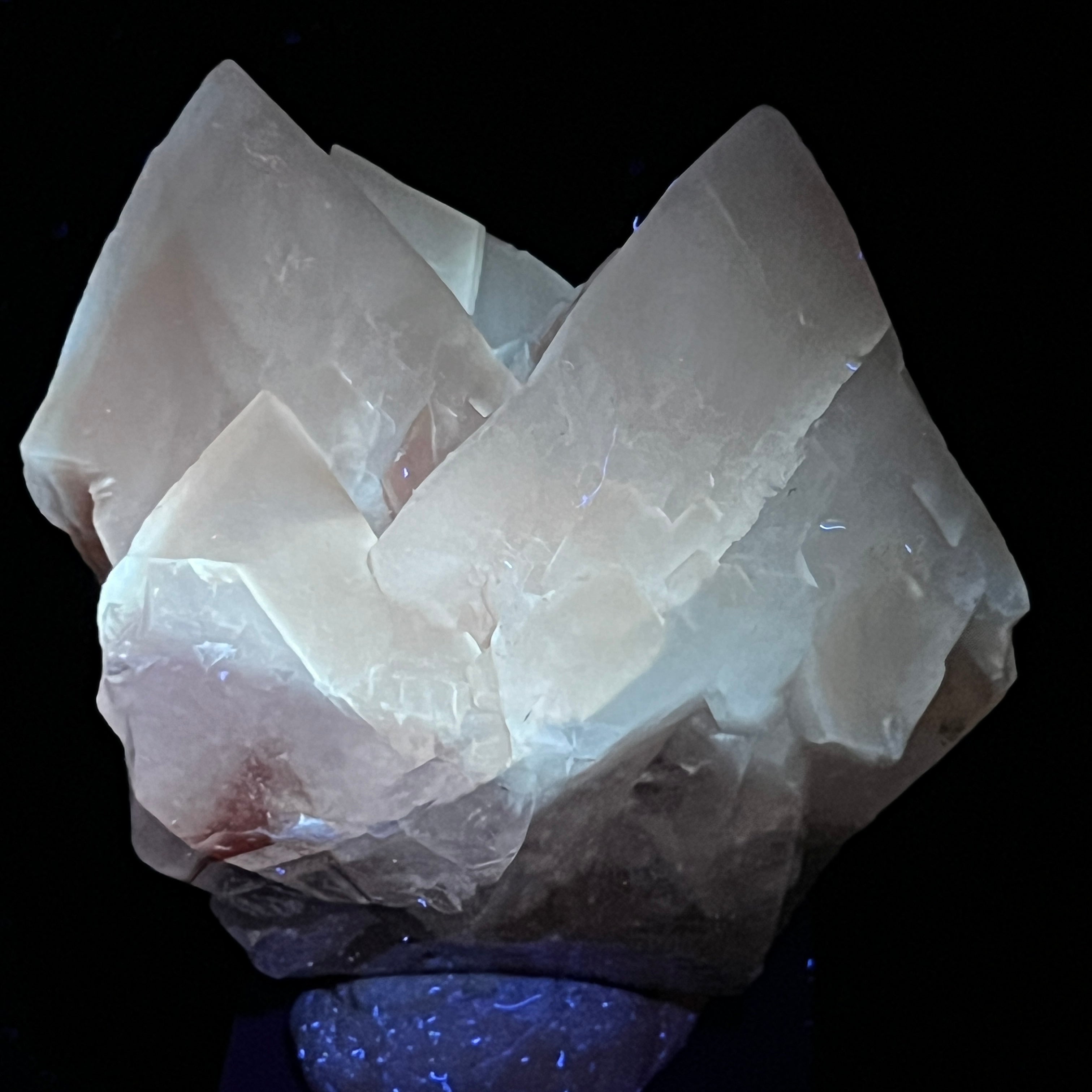 Very UV reactive, these Calcite crystals glow a profound cool, ghostly cream or white color when exposed to longwave UV light. Applied shortwave UV light may cause fluorescence that is reddish in color due to the presence of manganese in the basal / lower or first phase, rhombohedral, calcite growth.