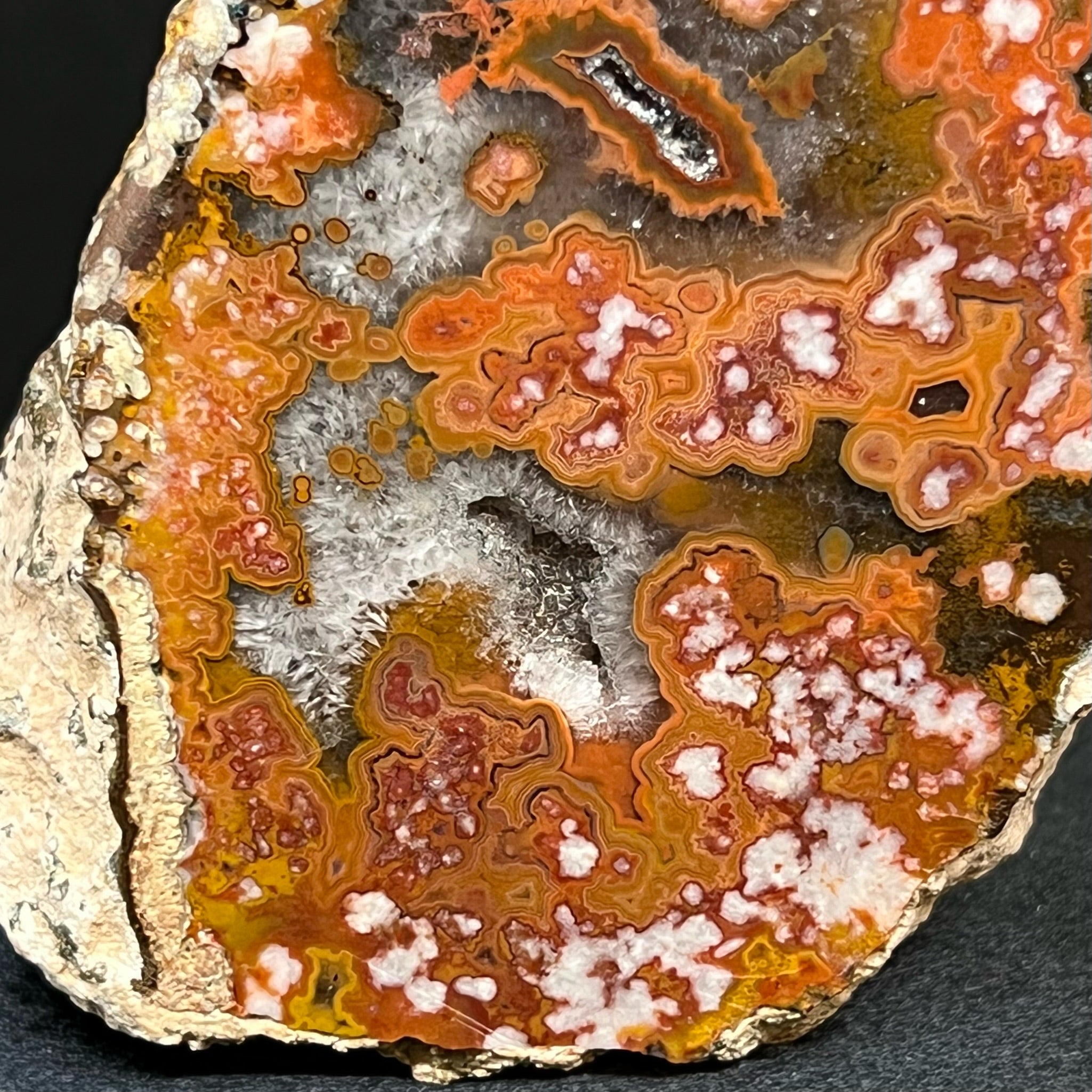 The white quartz var. chalcedony areas in this Moroccan Agate that present like cotton balls and flowers have a plume-like characteristic.