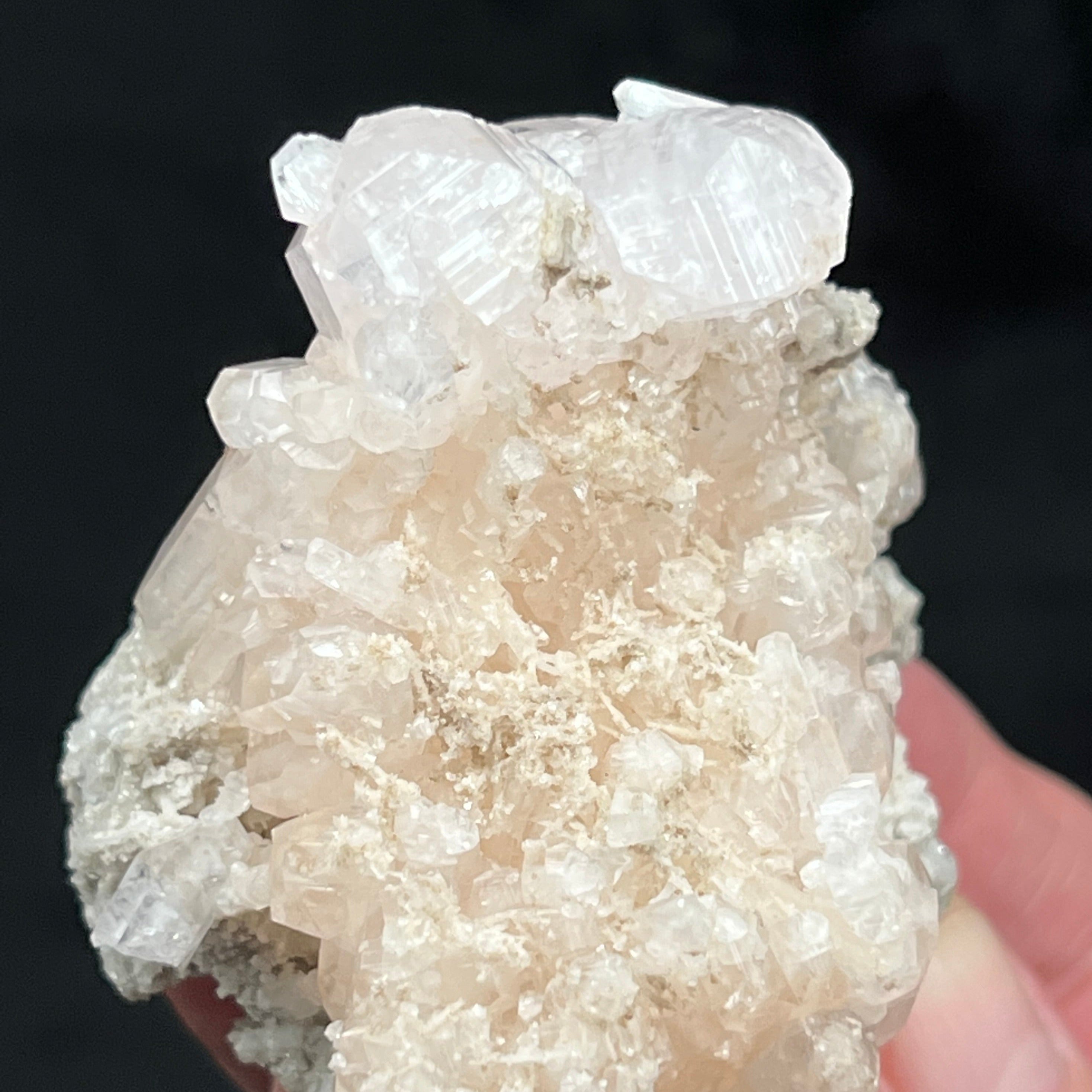 The Calcite presents as stalactitic with long icicle-like formations, some scepter-like, translucent to transparent double terminated prismatic crystals, and rhombohedral crystals perched primarily on one side and at the top of the specimen.