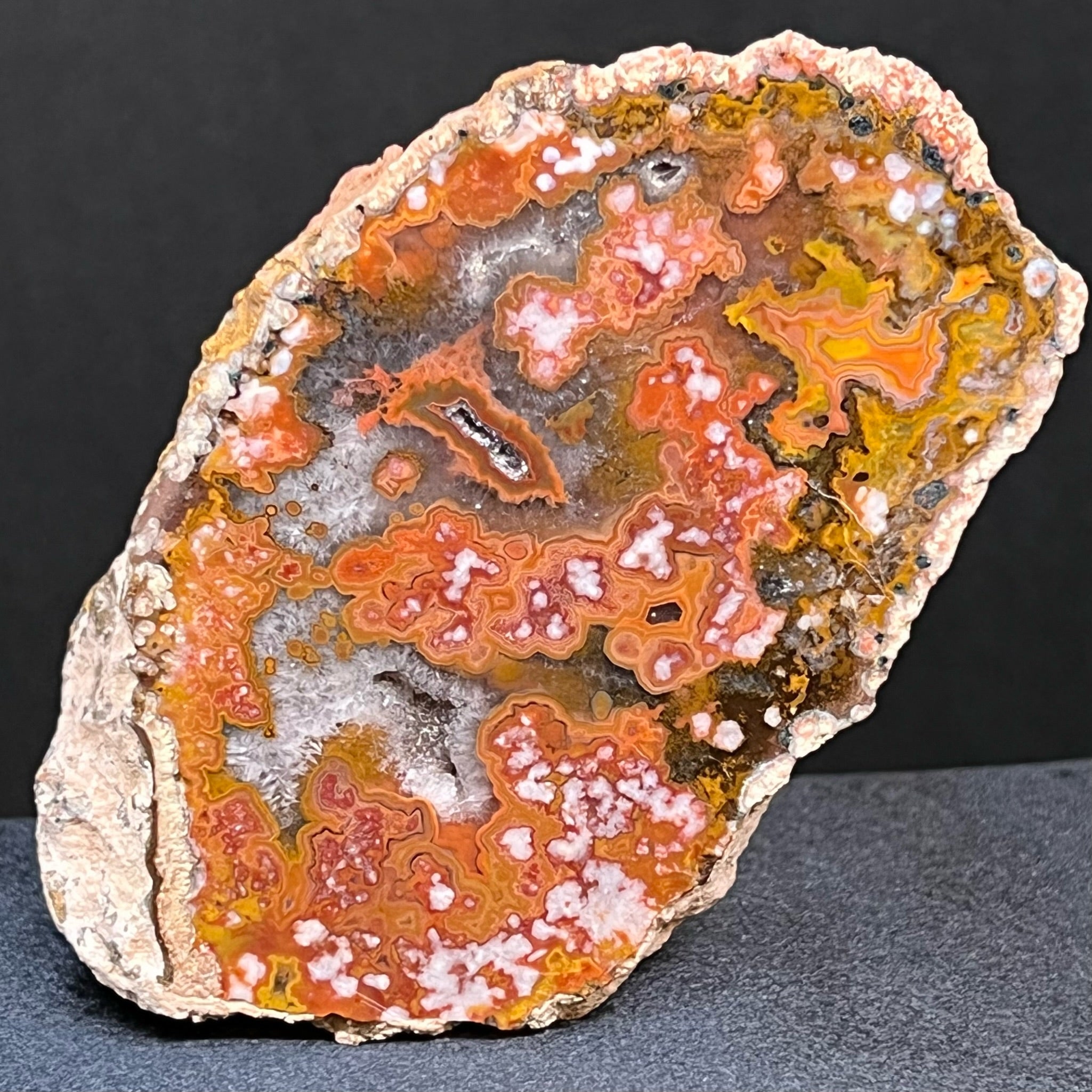 This is an exceptional, intricately patterned, quality Moroccan Agate specimen with a polished face that presents with banding, fortification, orbs, and small crystalline vugs or pockets of sparkling chalcedony druzy.