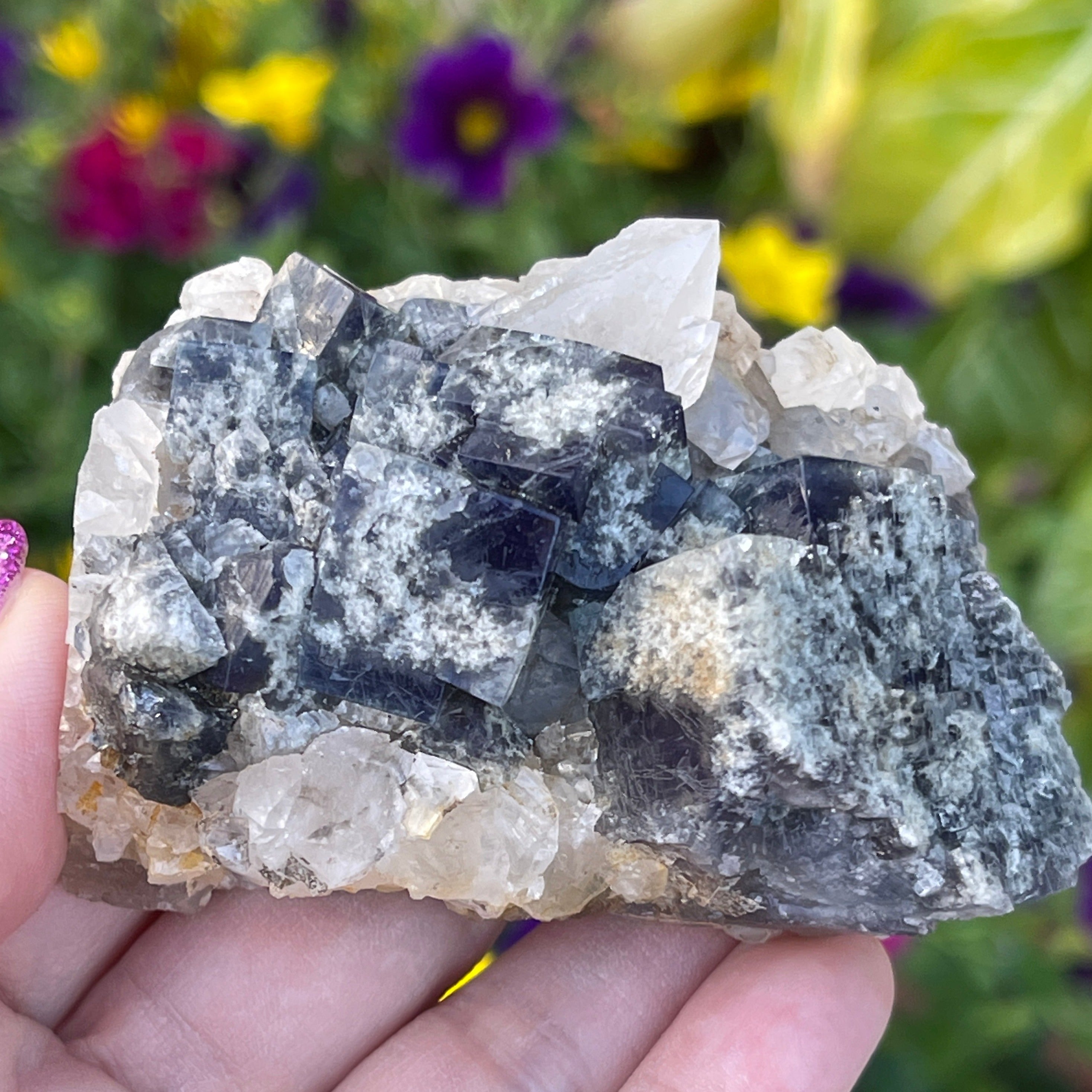 Milky Way Fluorite on a bed on Quartz with one prominent quartz point within the cluster. Unique specimen.