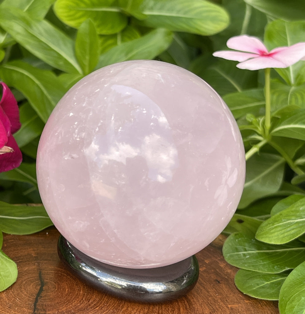 Large, round, pink sphere on stand taken outdoors