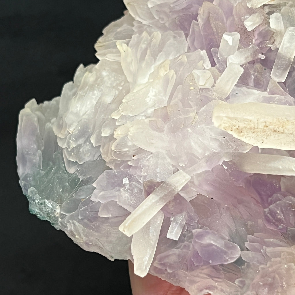 Both the Amethyst and Calcite crystals in this fine specimen present variably, some with smooth facets and faces, others with sort of lightly frosted, stippled surfaces and facets.
