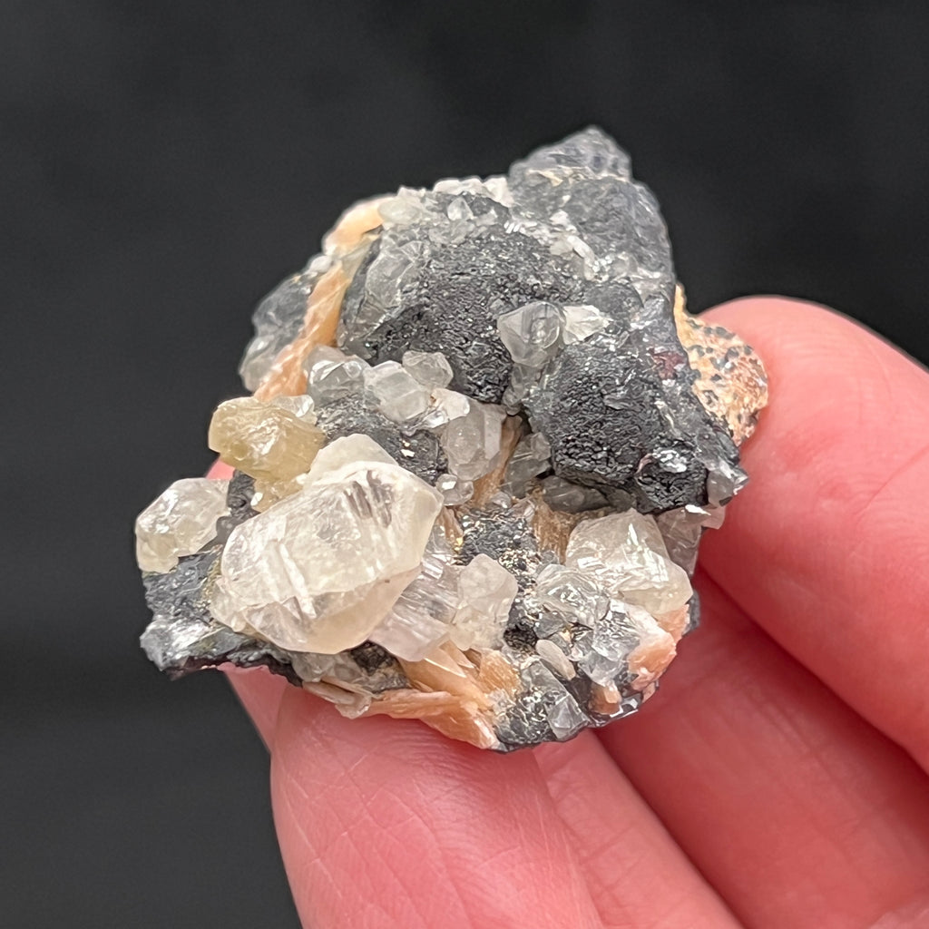 The Galena is not only the "mother" mineral for the secondary lead carbonate mineral Cerussite, it provides a nice contrast for the orange-pink Barite and Cerussite crystals.