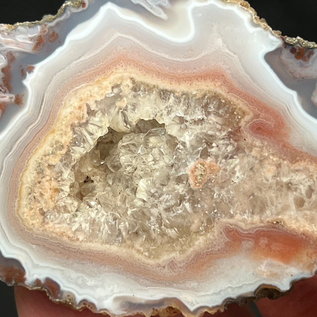 Along with the sparkly pocket of crystals, the designs and structures of this exceptional agate from Asni Cercle, Morocco exhibit varying colors from yellow to cream to pink and red.