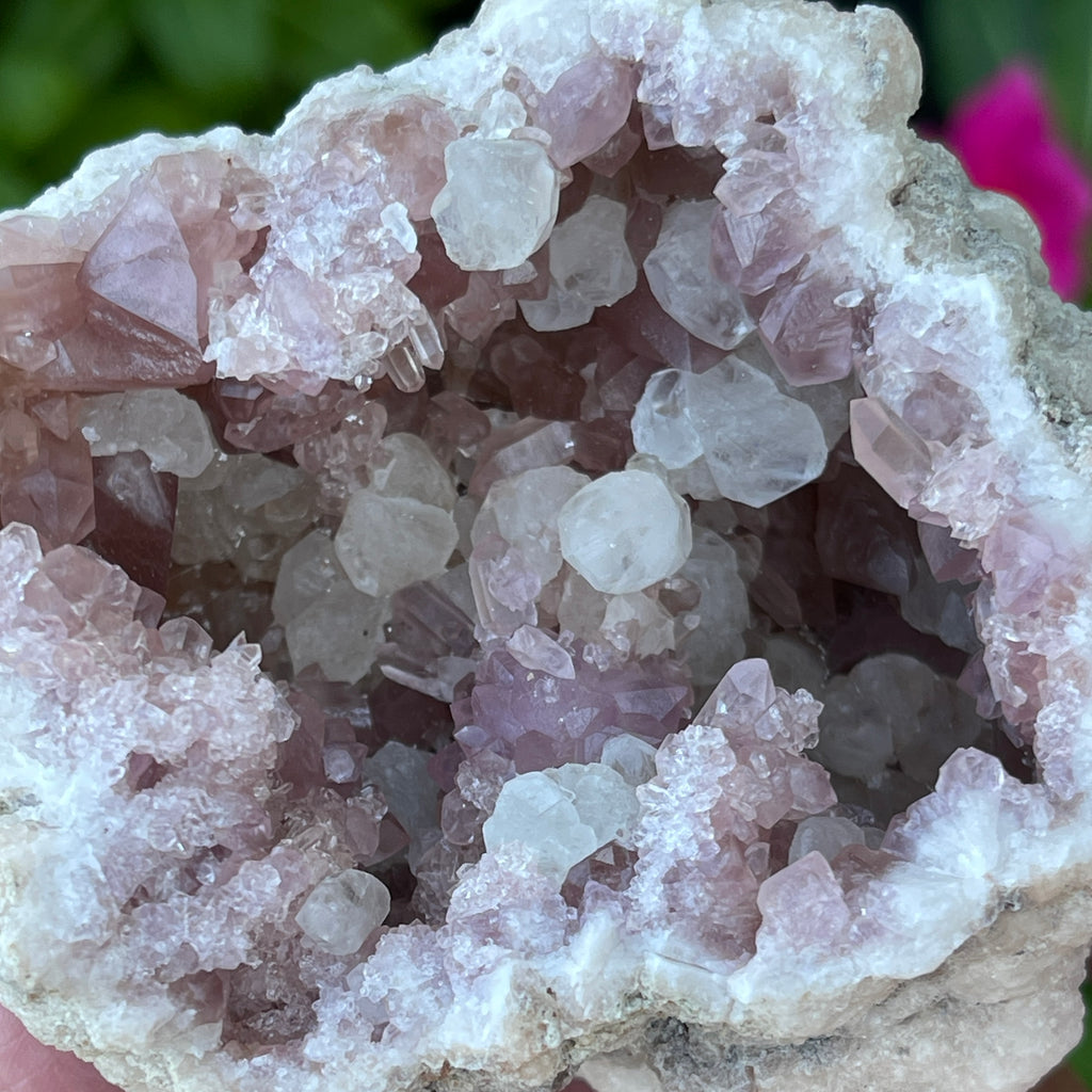 The 290 grams side of this geode presents with gorgeous Calcite crystals and a rosette ball formation of Pink Amethyst crystals.