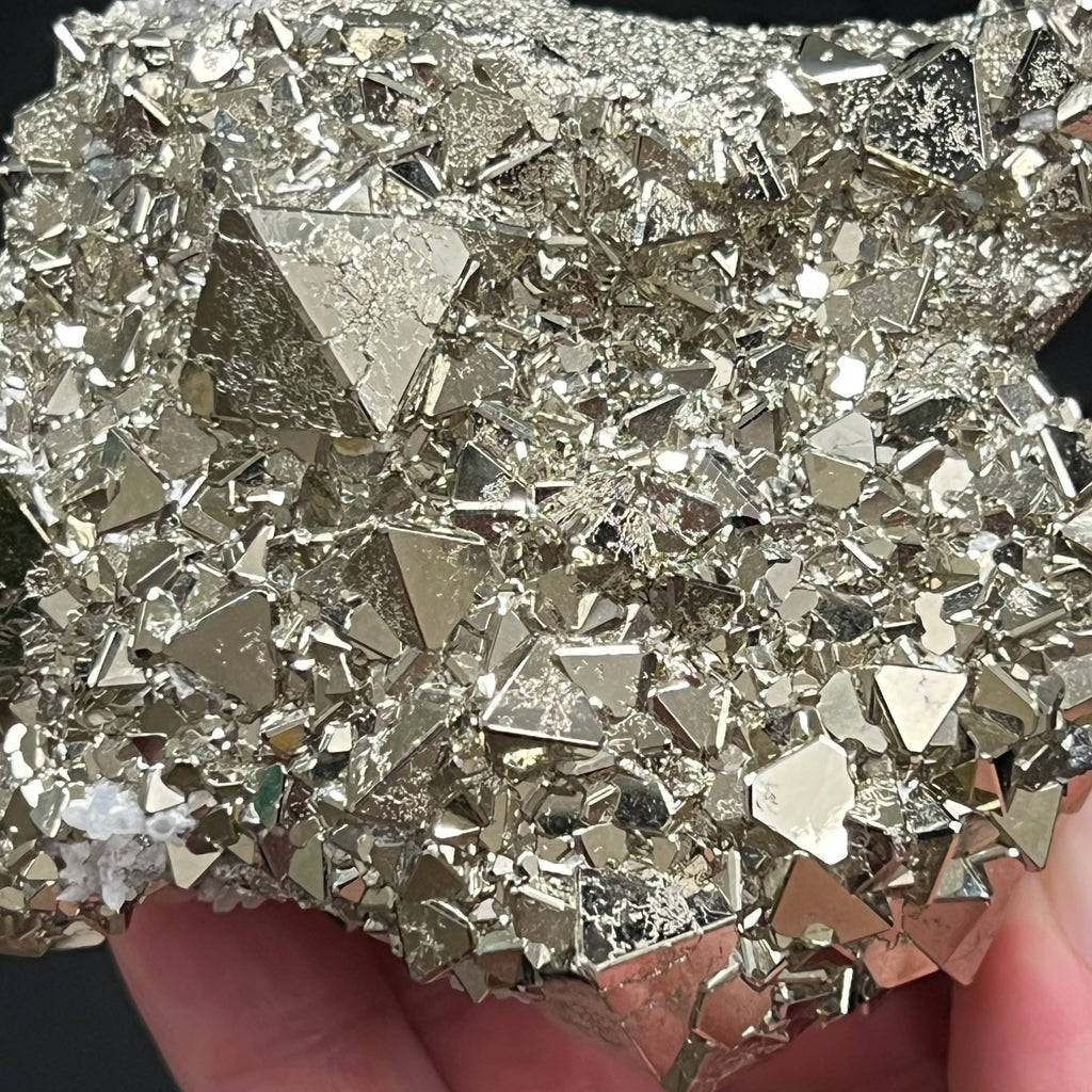Many of the faces of the well formed octahedral Pyrite crystals are smooth and brightly reflective, other faces, while exhibiting the same higher quality, present a fascinating etched like, maze looking polycrystalline growth.