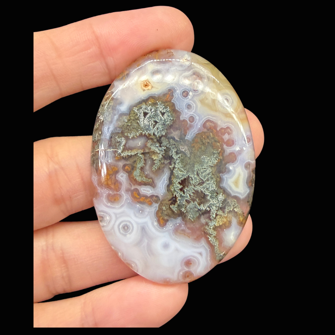 Red and Green Moss Agate Cabochon shown in hand.