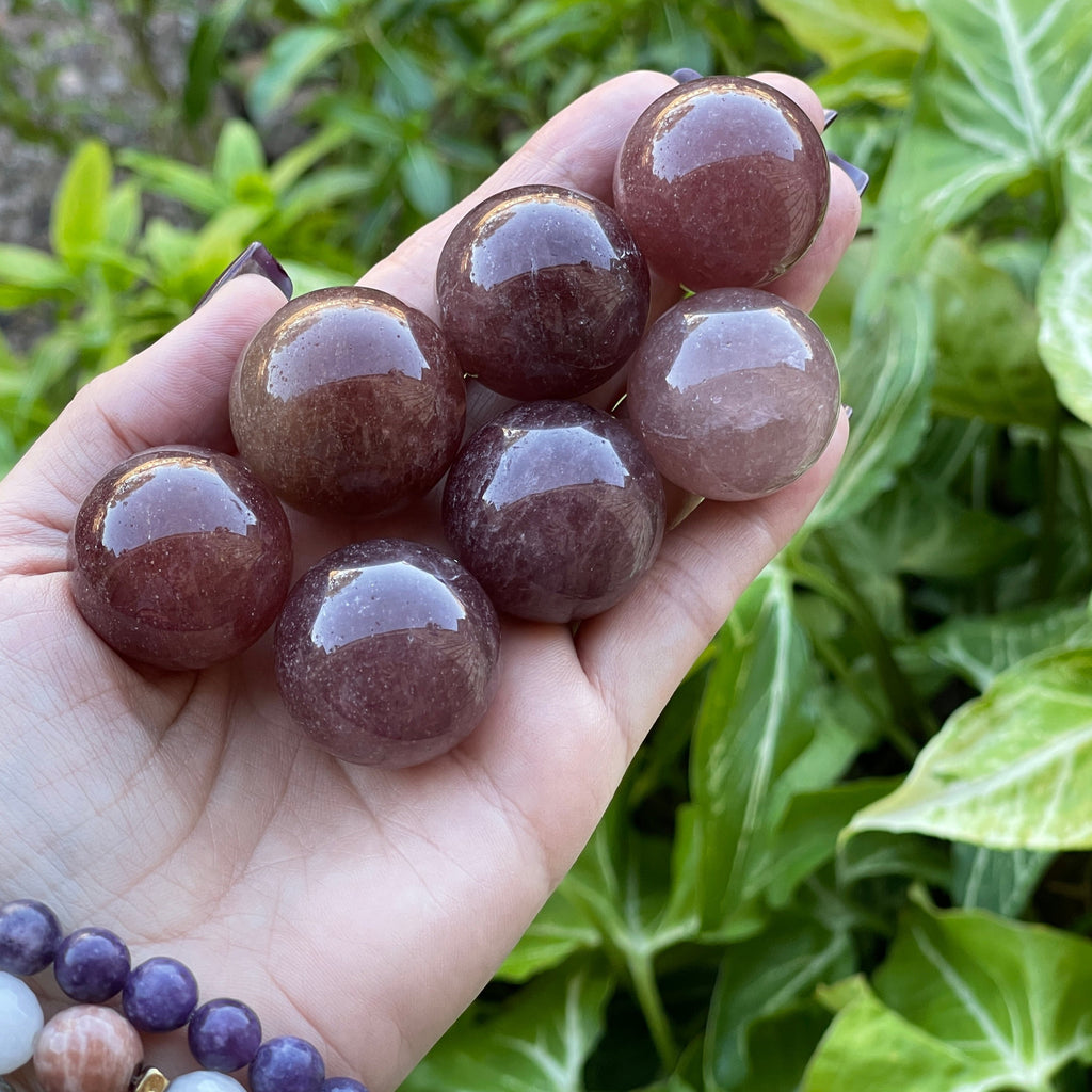Tanzberry, Cherry Quartz spheres, shown in hand.