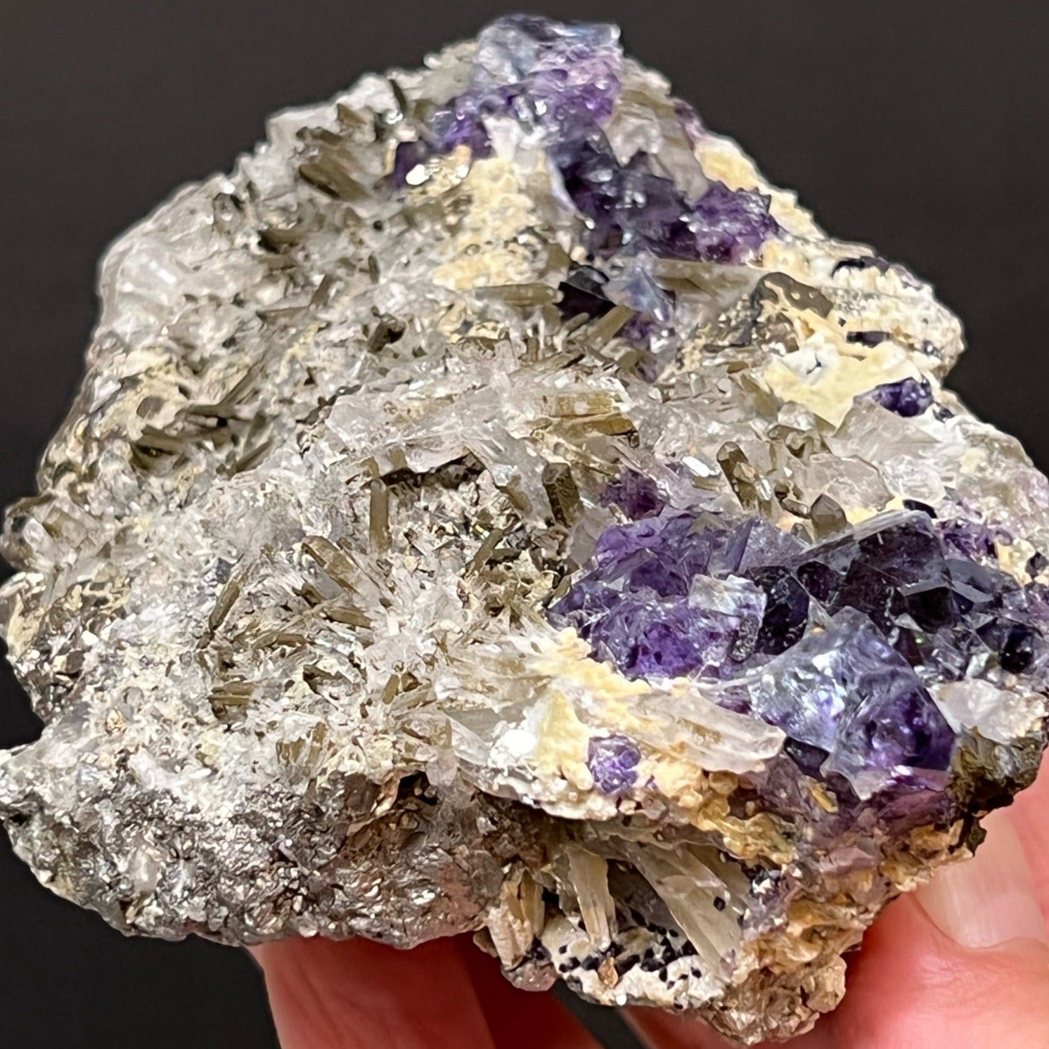 Refracted light in the form of gorgeous rainbow colors is evident from within and on the surface of the Fluorite crystals. The yellowish-brown, tannish, cream colored Muscovite presents nestled in between the Fluorite and Needle Quartz and is a wonderful addition to the variety of minerals that present in is this cool, complex, combo specimen.