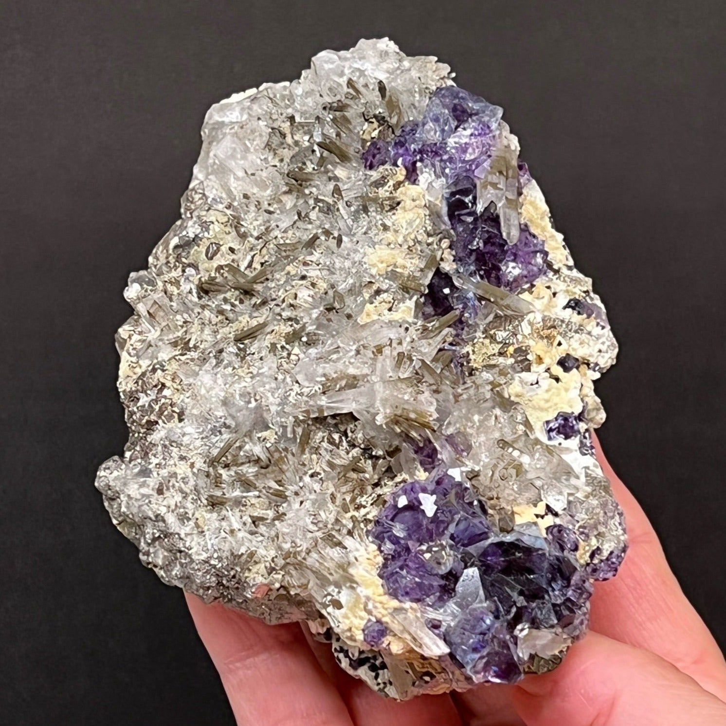 Iridescent flashes of color emanate exquisitely from some of the shiny, striated Pyrite and Chalcopyrite in this specimen.